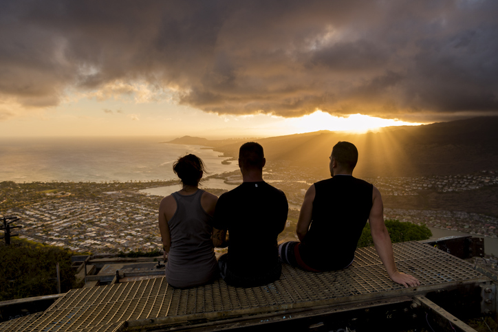 3 hikers watch Oahu sunset