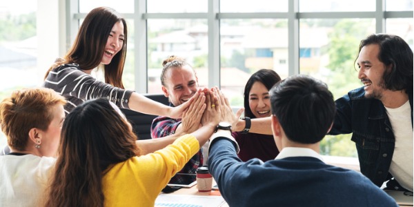 group of young professionals giving high fives