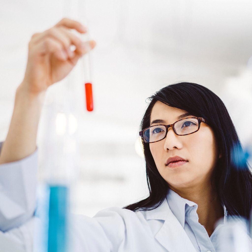 Female scientist analyzing sample in test tube