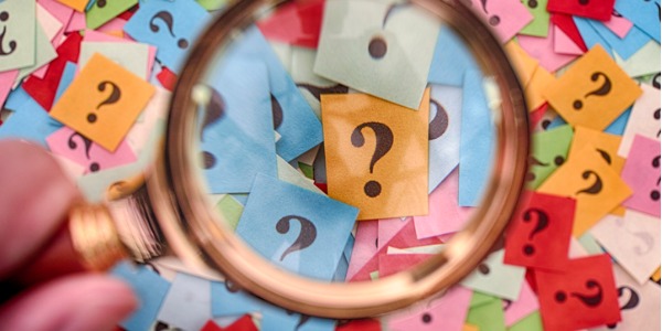 Question marks with magnifying glass